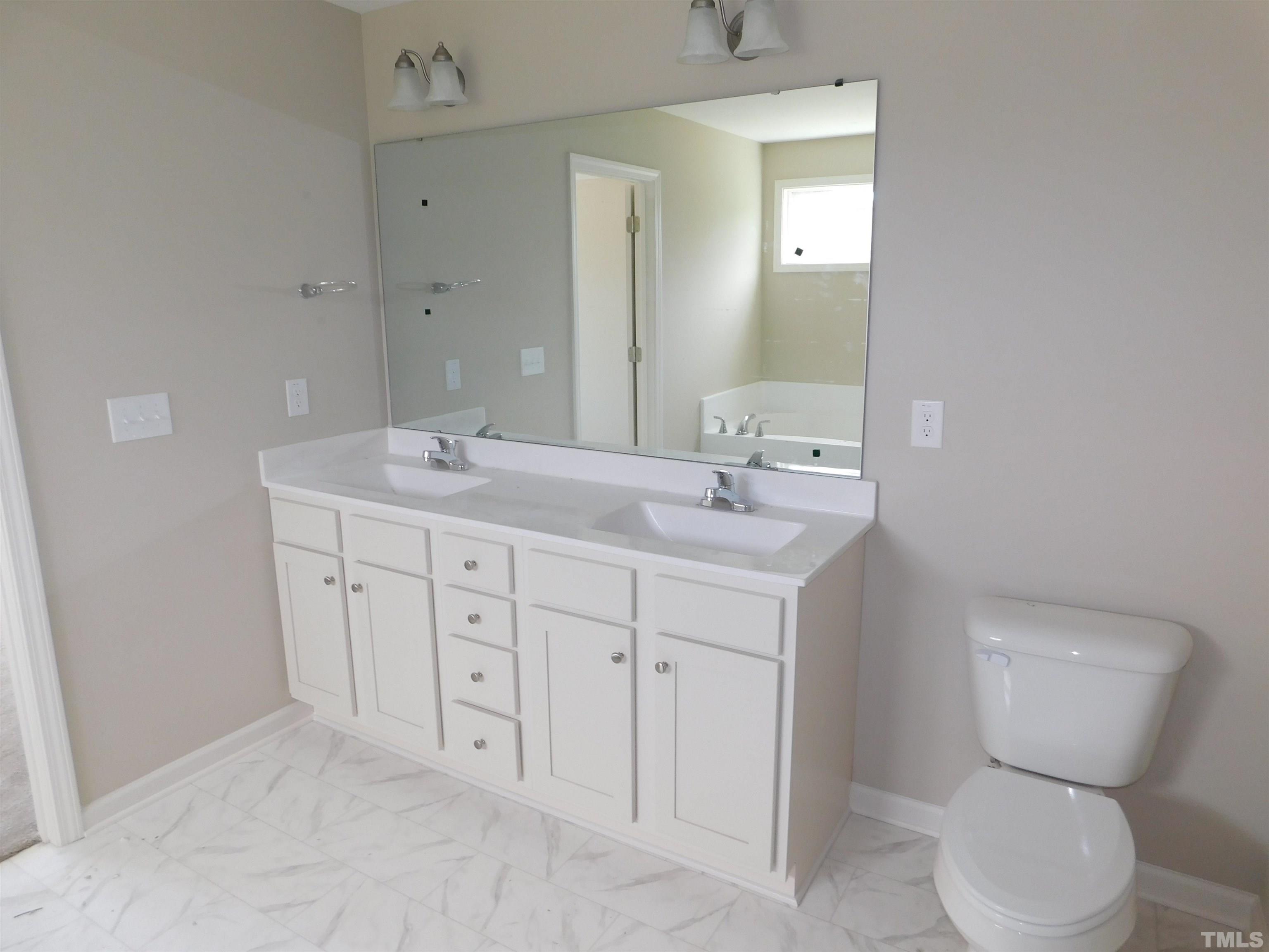 84 Kickoff Circle Benson, NC 27504 - Photo 11 of 21 a spacious bathroom with a toilet sink and mirror