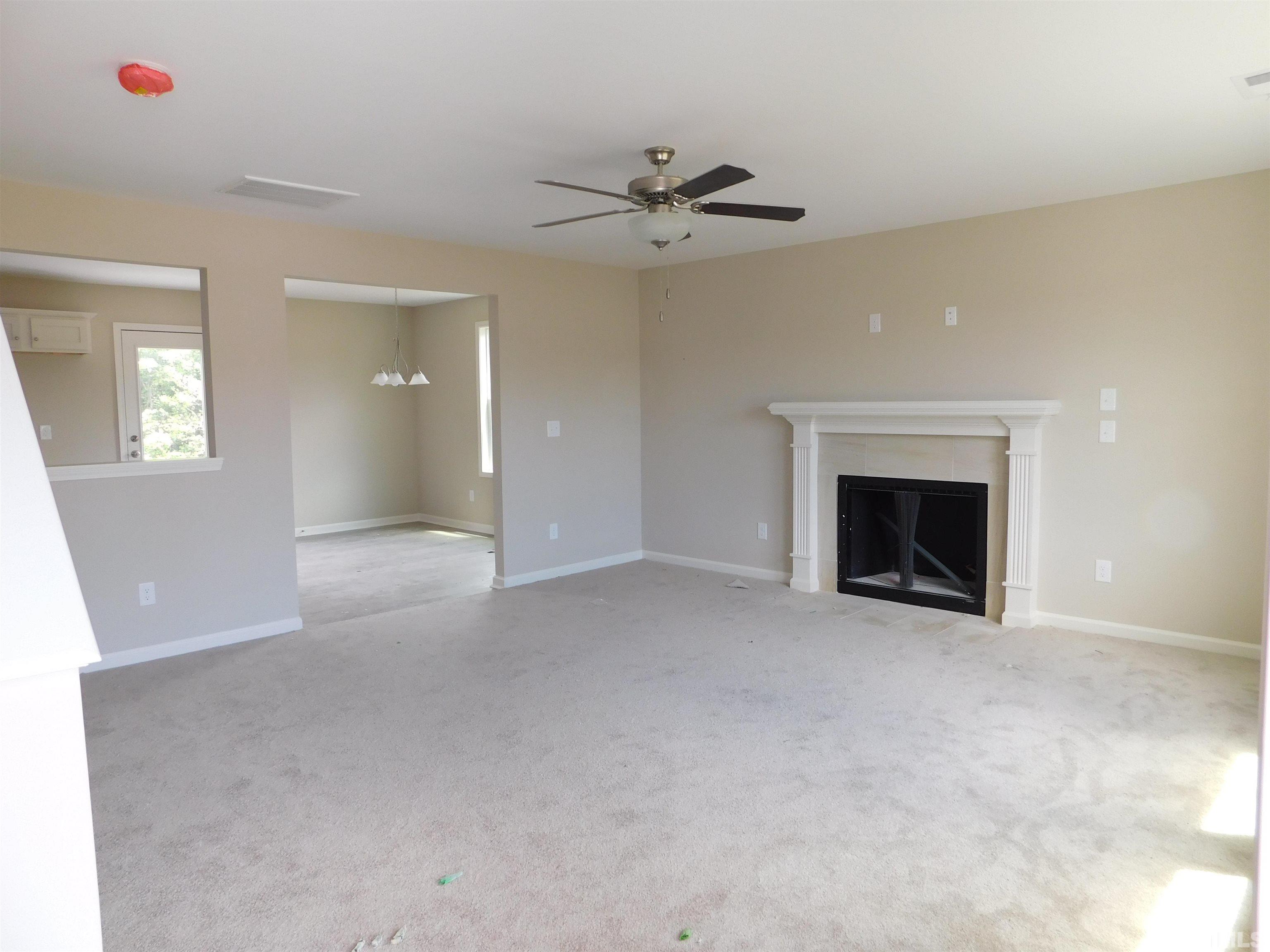 84 Kickoff Circle Benson, NC 27504 - Photo 4 of 21 a view of an empty room with a fireplace and a window