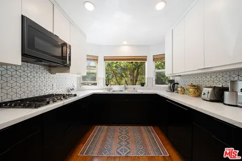 a large kitchen with kitchen island a counter space a sink a stove and refrigerator