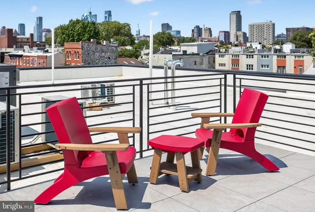a view of a dining room with furniture and a red umbrella