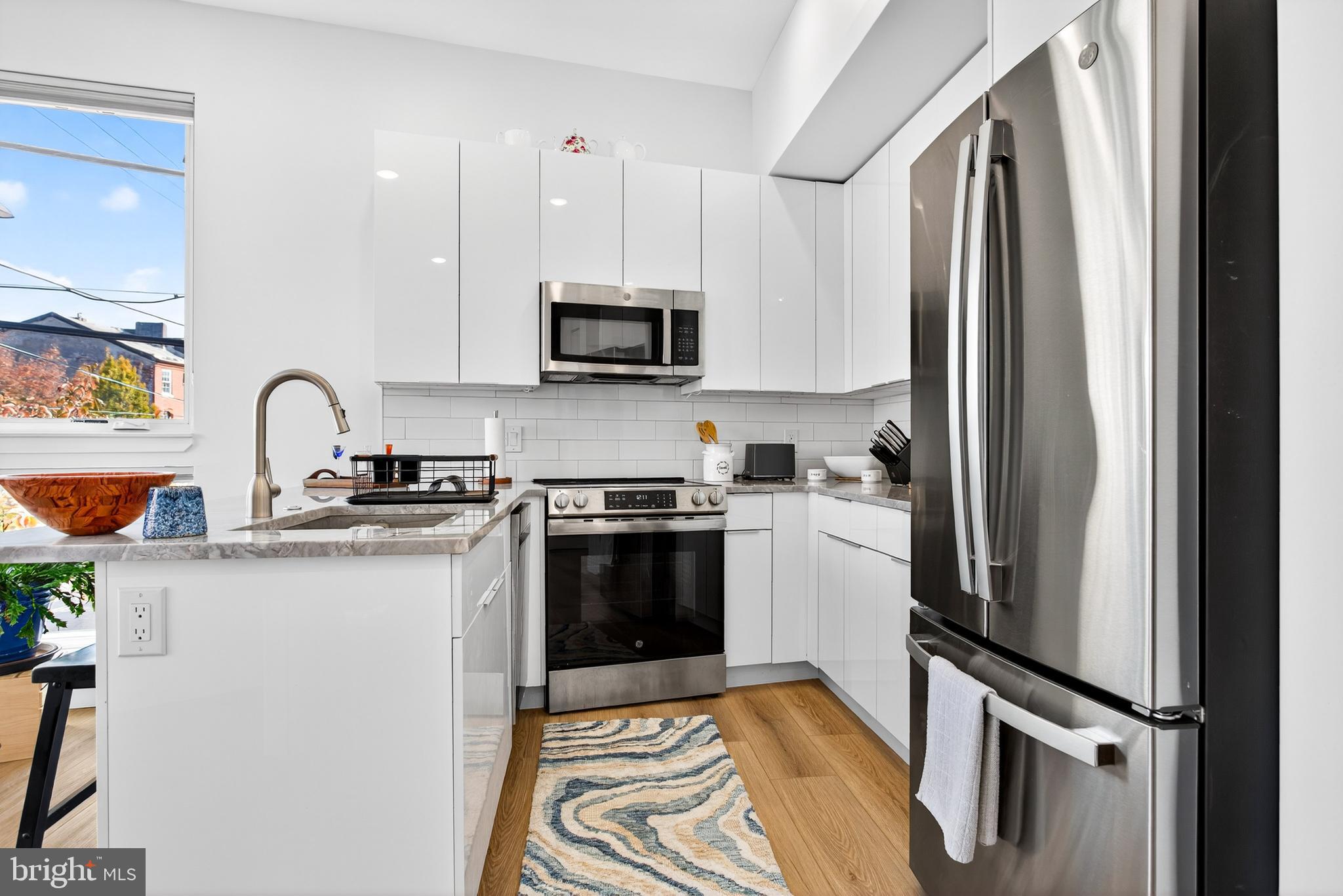 300 Christian Street, Unit 211 Philadelphia, PA 19147 - Photo 6 of 30 a kitchen with stainless steel appliances granite countertop a refrigerator sink and white cabinets