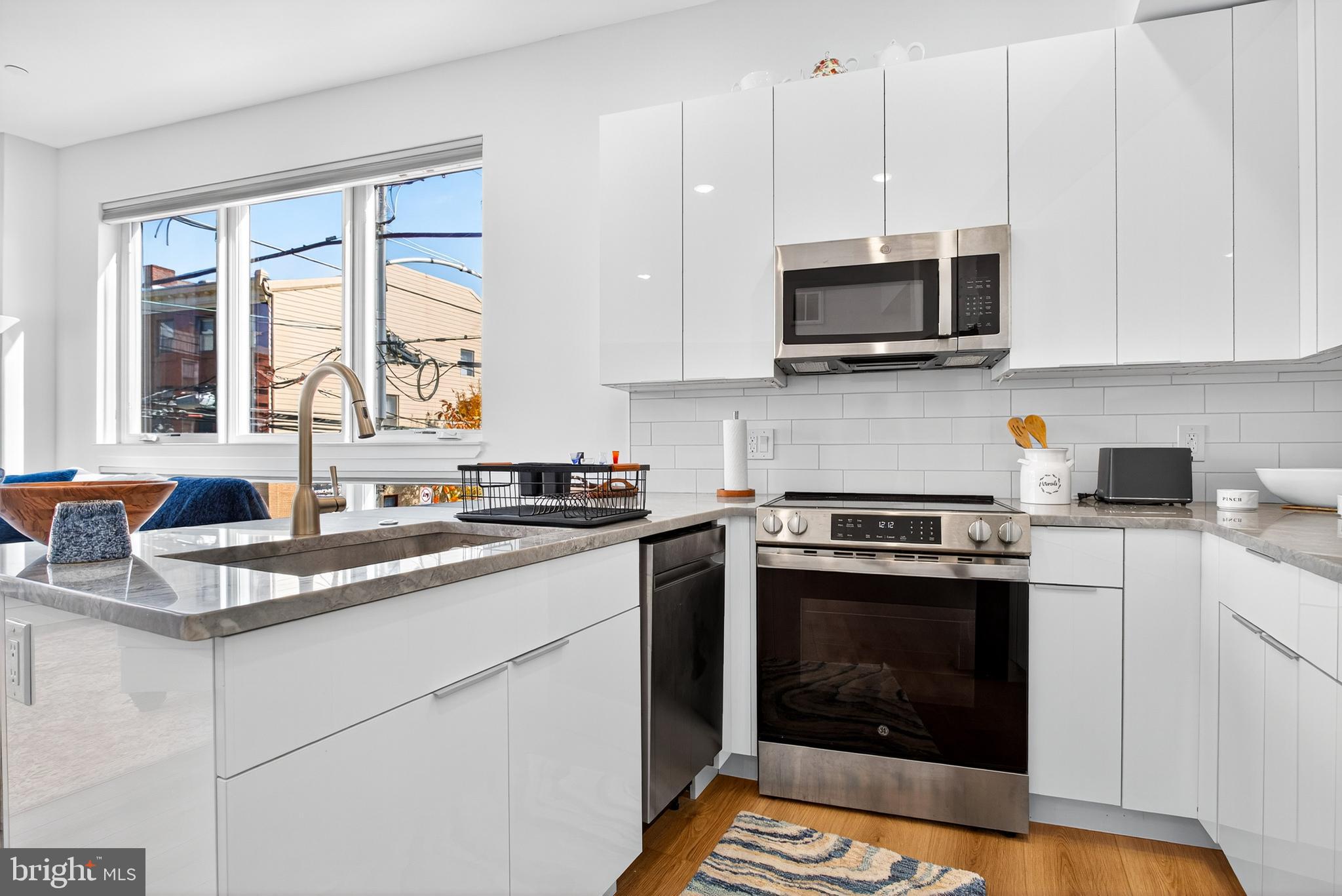 300 Christian Street, Unit 211 Philadelphia, PA 19147 - Photo 7 of 30 a kitchen with stainless steel appliances granite countertop a stove a sink and a microwave