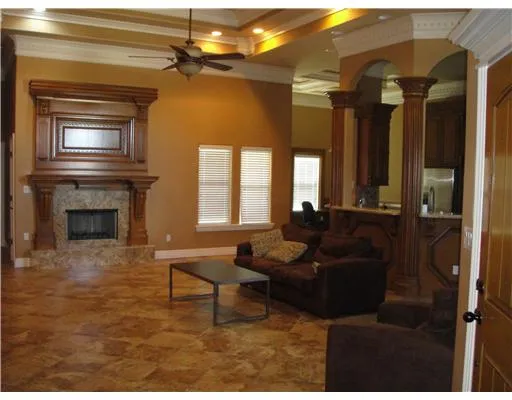 a living room with furniture a fireplace and a chandelier