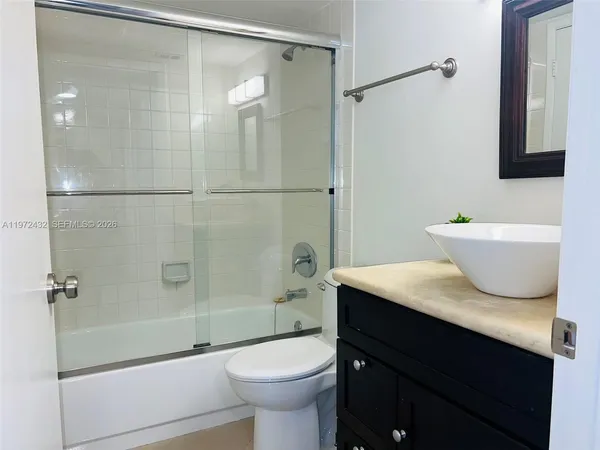 a bathroom with a sink vanity granite tub and shower