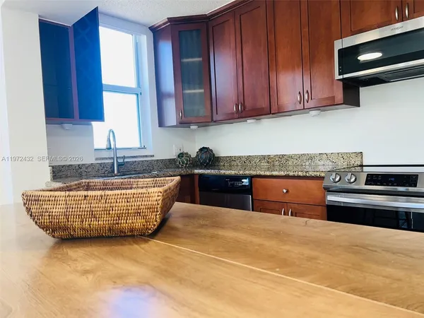 a kitchen with a sink a window and cabinets