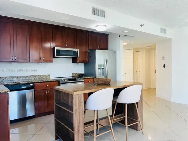 a kitchen with stainless steel appliances wooden cabinets granite counter tops and a stove top oven