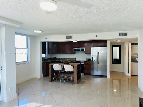 a kitchen with stainless steel appliances a sink a counter top space cabinets and stainless steel appliances