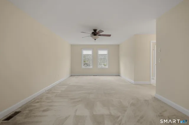 a spacious bedroom with a bed a chandelier and a flat screen tv
