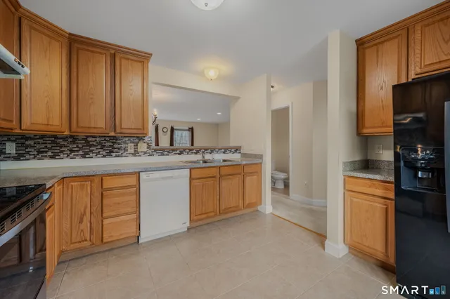 a kitchen with stainless steel appliances granite countertop a stove a sink and a refrigerator with cabinets