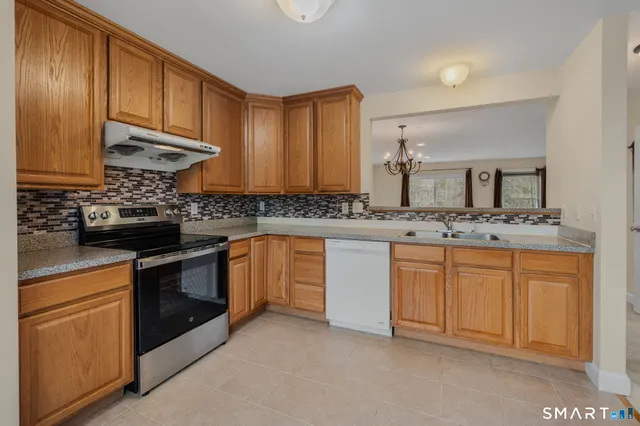 a kitchen with stainless steel appliances granite countertop a stove sink and cabinets