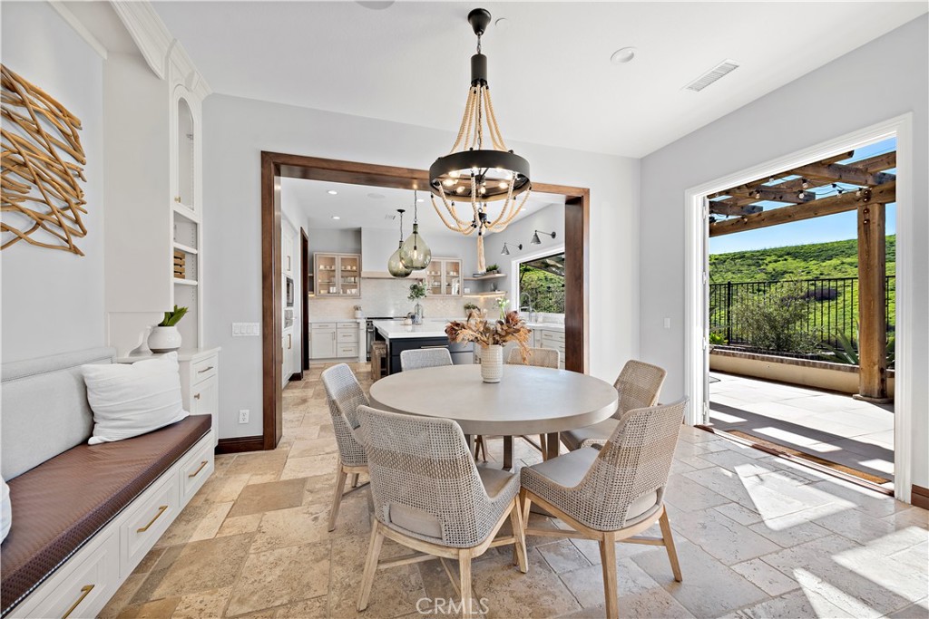 27 Pisano Street Ladera Ranch, CA 92694 - Photo 24 of 71 a dining room with wooden floor a chandelier a wooden table and chairs