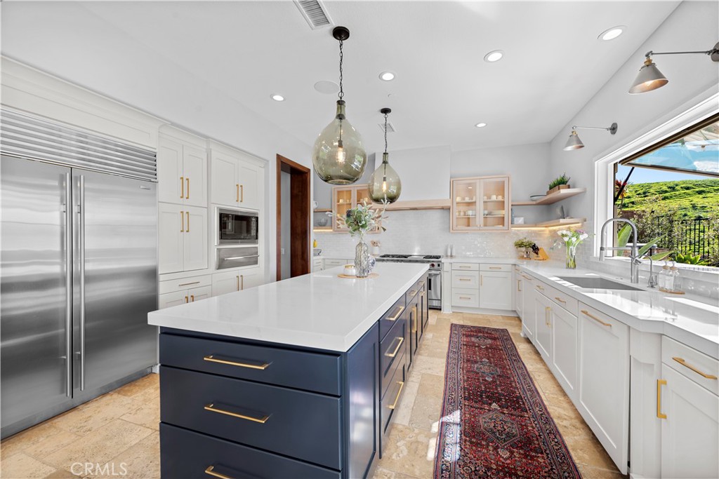 27 Pisano Street Ladera Ranch, CA 92694 - Photo 26 of 71 a large kitchen with kitchen island a large counter top space a sink stainless steel appliances and cabinets