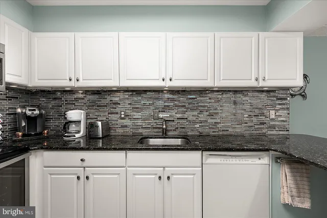 a kitchen with a stove and white cabinets