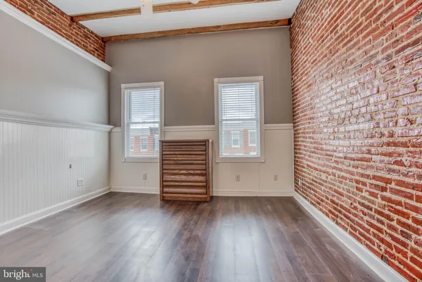 an empty room with wooden floor and white walls