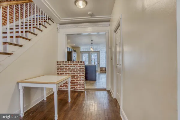 a view of a hallway with wooden floor and dining room