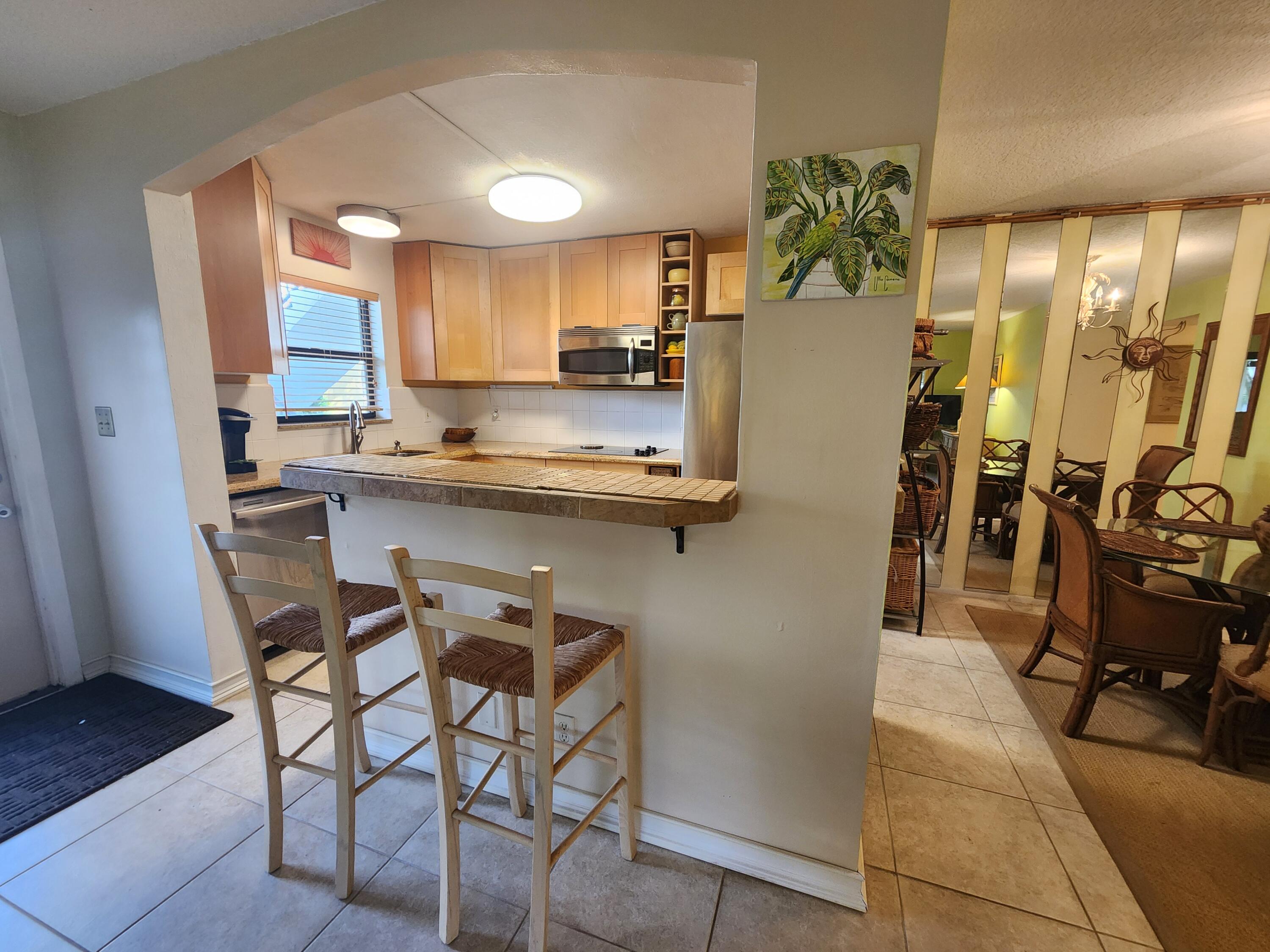 501 Dotterel Road, Unit 26B Delray Beach, FL 33444 - Photo 12 of 48 a kitchen with stainless steel appliances a sink a stove a refrigerator and cabinets
