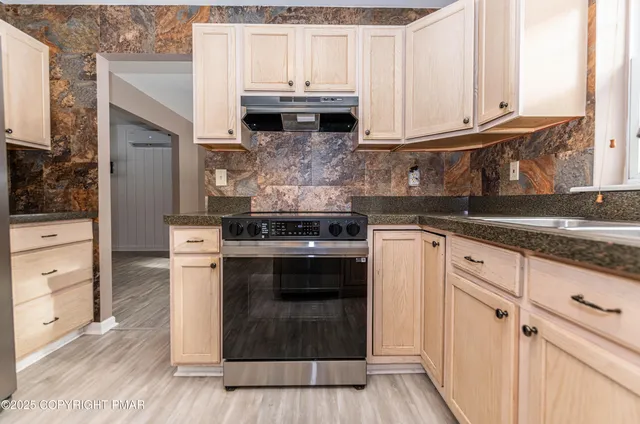 a view of a kitchen with wooden floor and a window