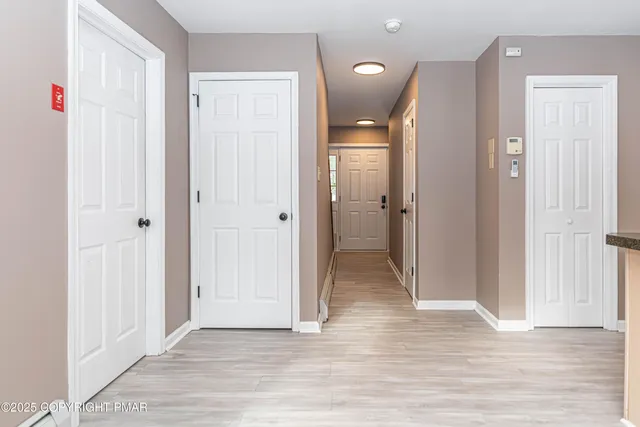 a view of an empty room with a window and wooden floor