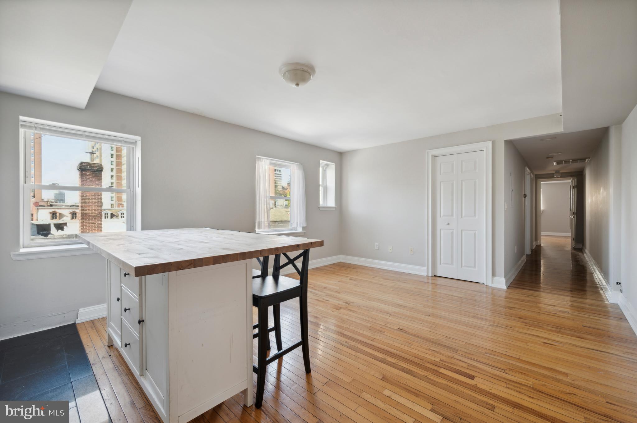 1723 Spruce Street Philadelphia, PA 19103 - Photo 16 of 24 a view of a kitchen and an empty room with wooden floor and a window