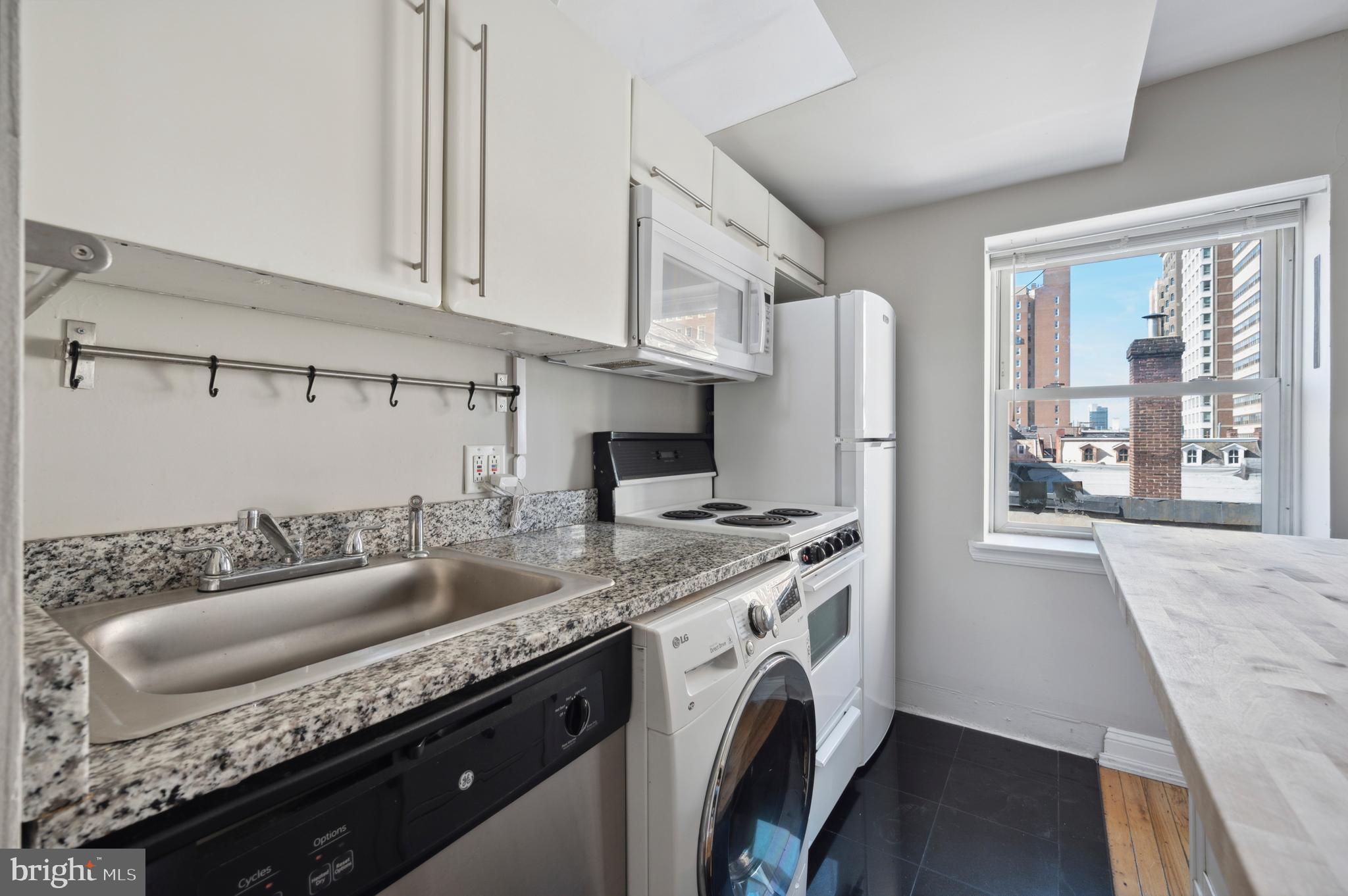 1723 Spruce Street Philadelphia, PA 19103 - Photo 20 of 24 a kitchen with granite countertop a sink a stove and a wooden floors