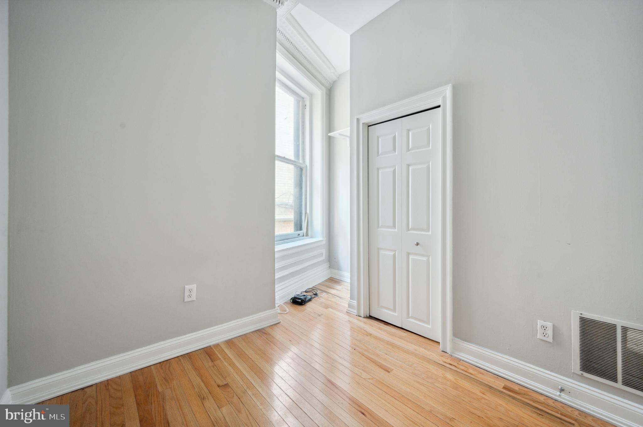 1723 Spruce Street Philadelphia, PA 19103 - Photo 10 of 24 an empty room with wooden floor and windows