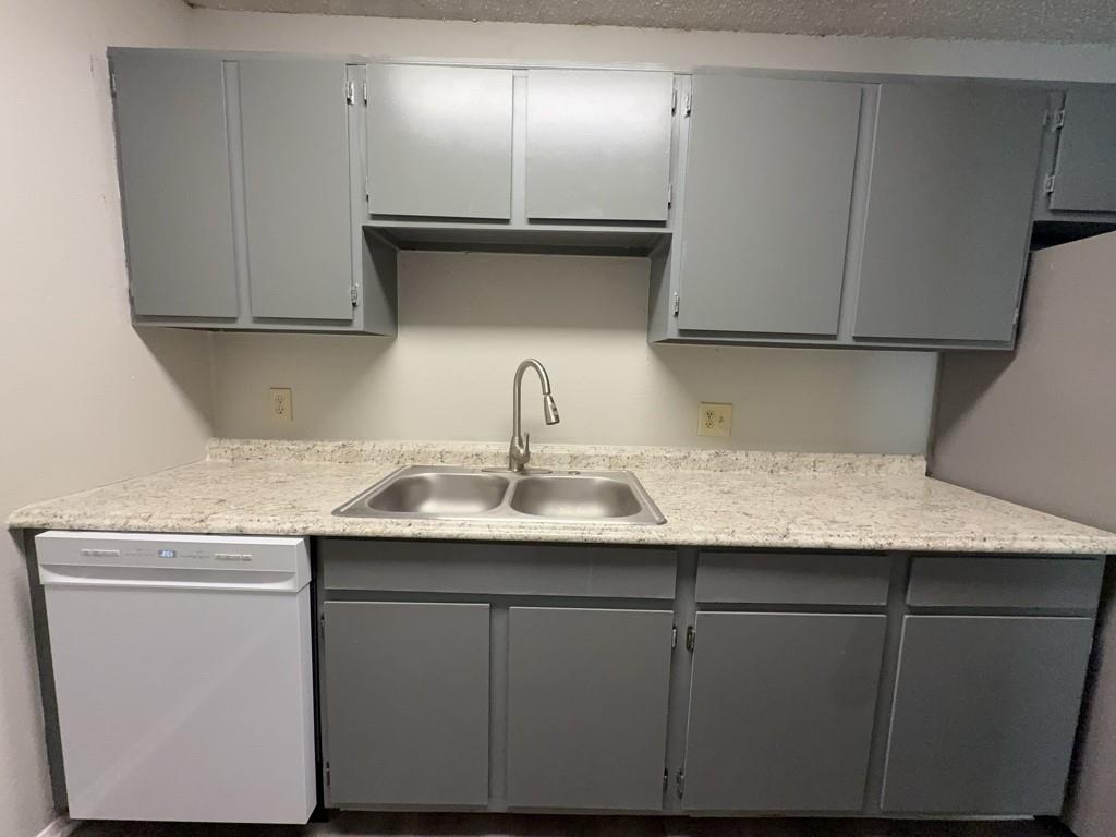 219 Fry Street, Unit 6 Denton, TX 76201 - Photo 13 of 29 a kitchen with a sink and a refrigerator