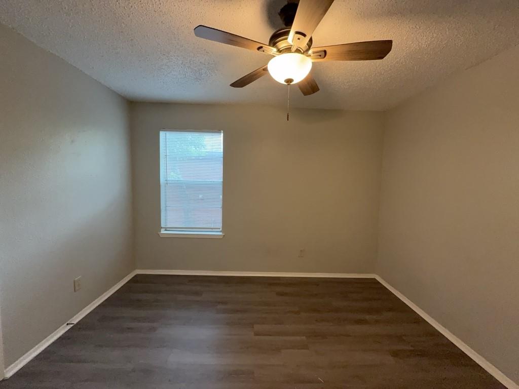 219 Fry Street, Unit 6 Denton, TX 76201 - Photo 19 of 29 an empty room with wooden floor fan and window