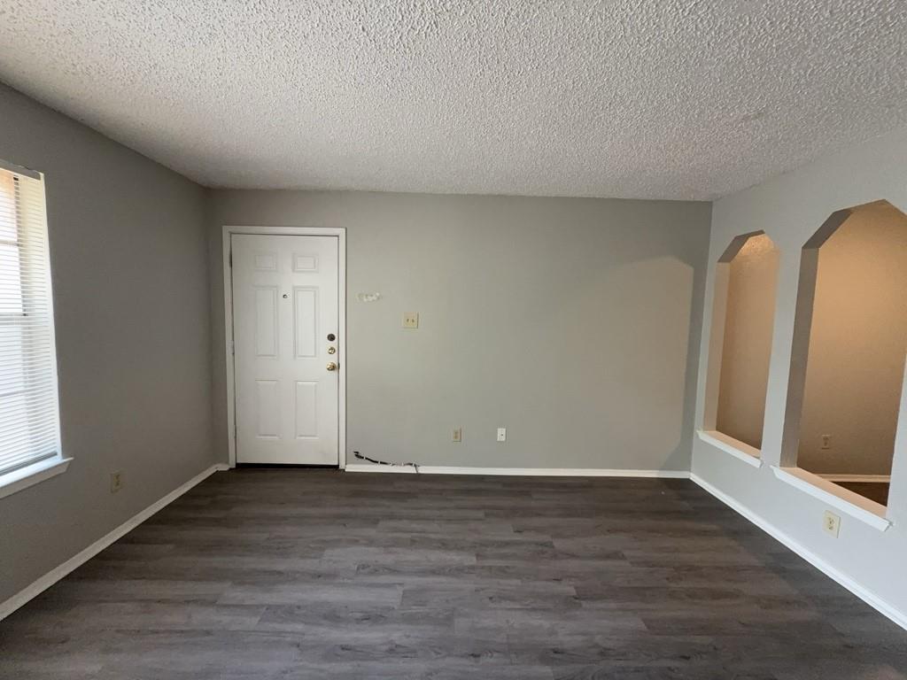 219 Fry Street, Unit 6 Denton, TX 76201 - Photo 7 of 29 an empty room with wooden floor and window