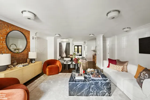 a living room with furniture a mirror and a chandelier