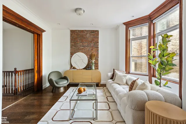 a living room with furniture a rug and a large window
