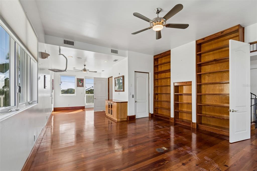 2811 Sunset Way St. Pete Beach, FL 33706 - Photo 62 of 97 a view of an empty room with wooden floor and a ceiling fan