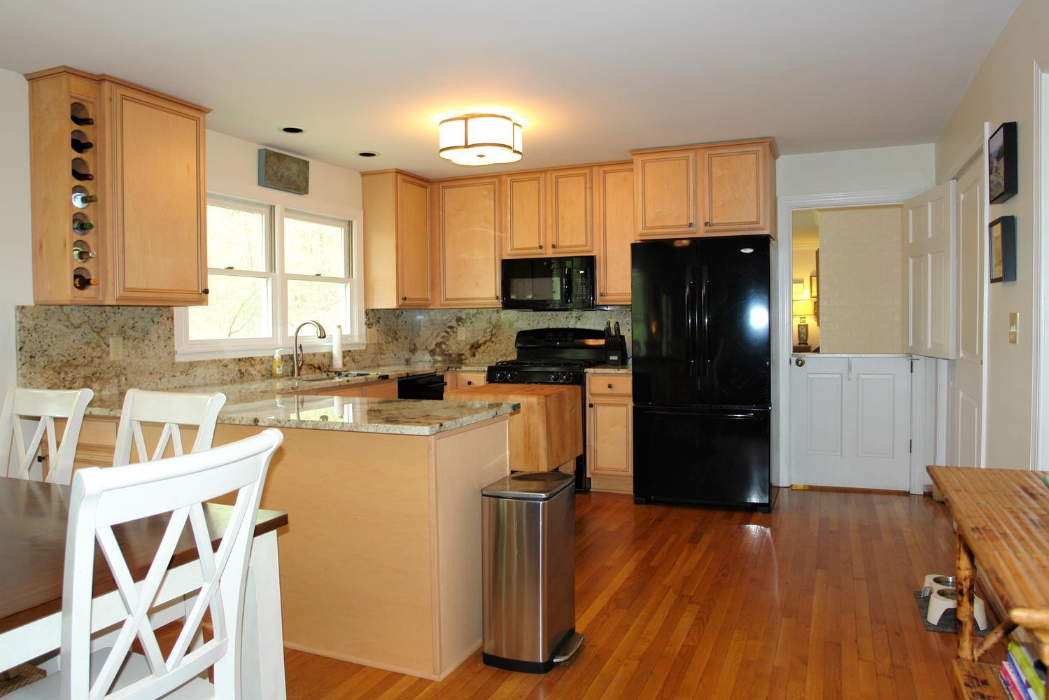 219 Darwin Road Southwest Roanoke, VA 24014 - Photo 13 of 58 a kitchen with granite countertop a refrigerator a stove a sink and wooden floors