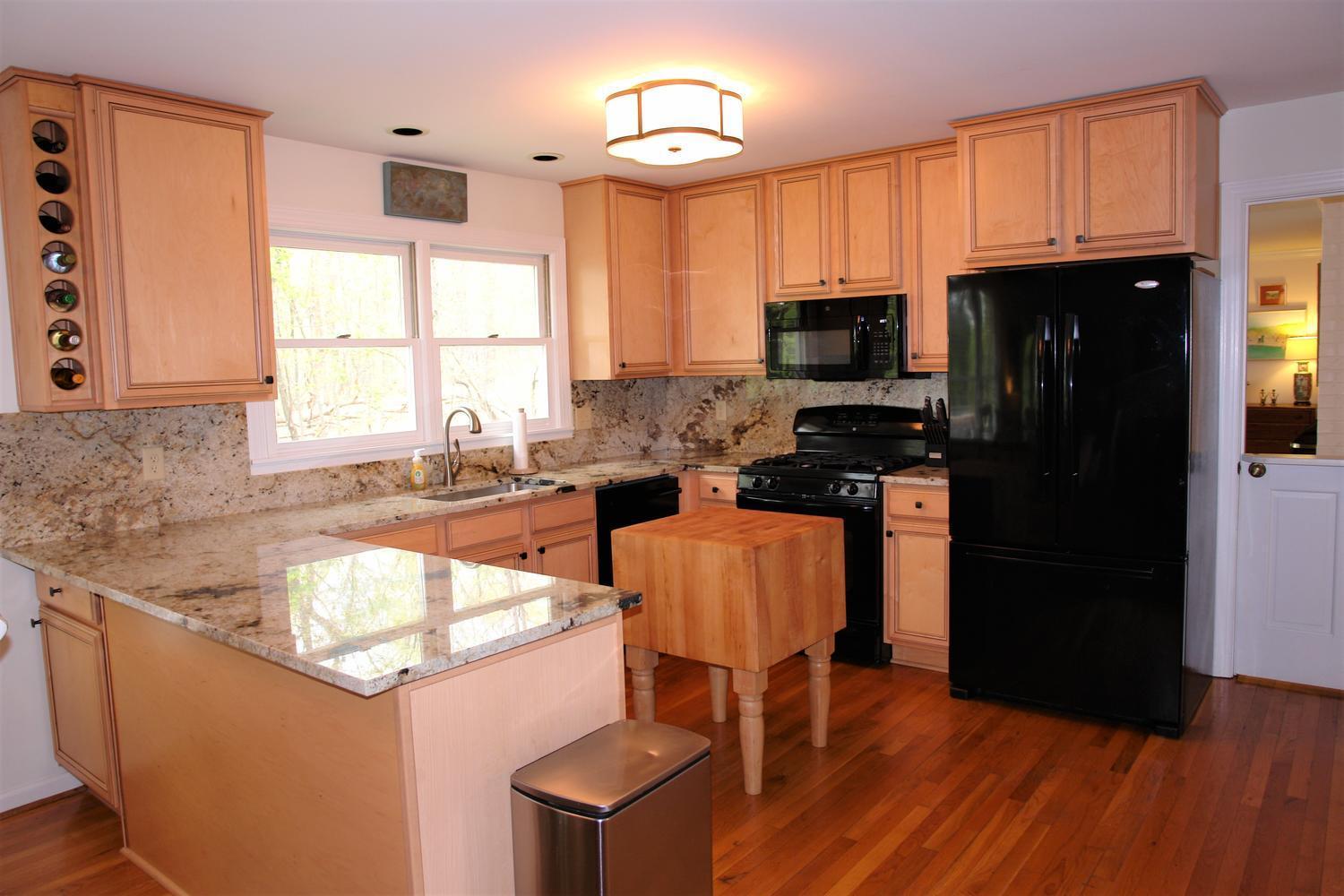 219 Darwin Road Southwest Roanoke, VA 24014 - Photo 14 of 58 a kitchen with stainless steel appliances granite countertop a stove a refrigerator a sink a dining table and chairs with wooden floor