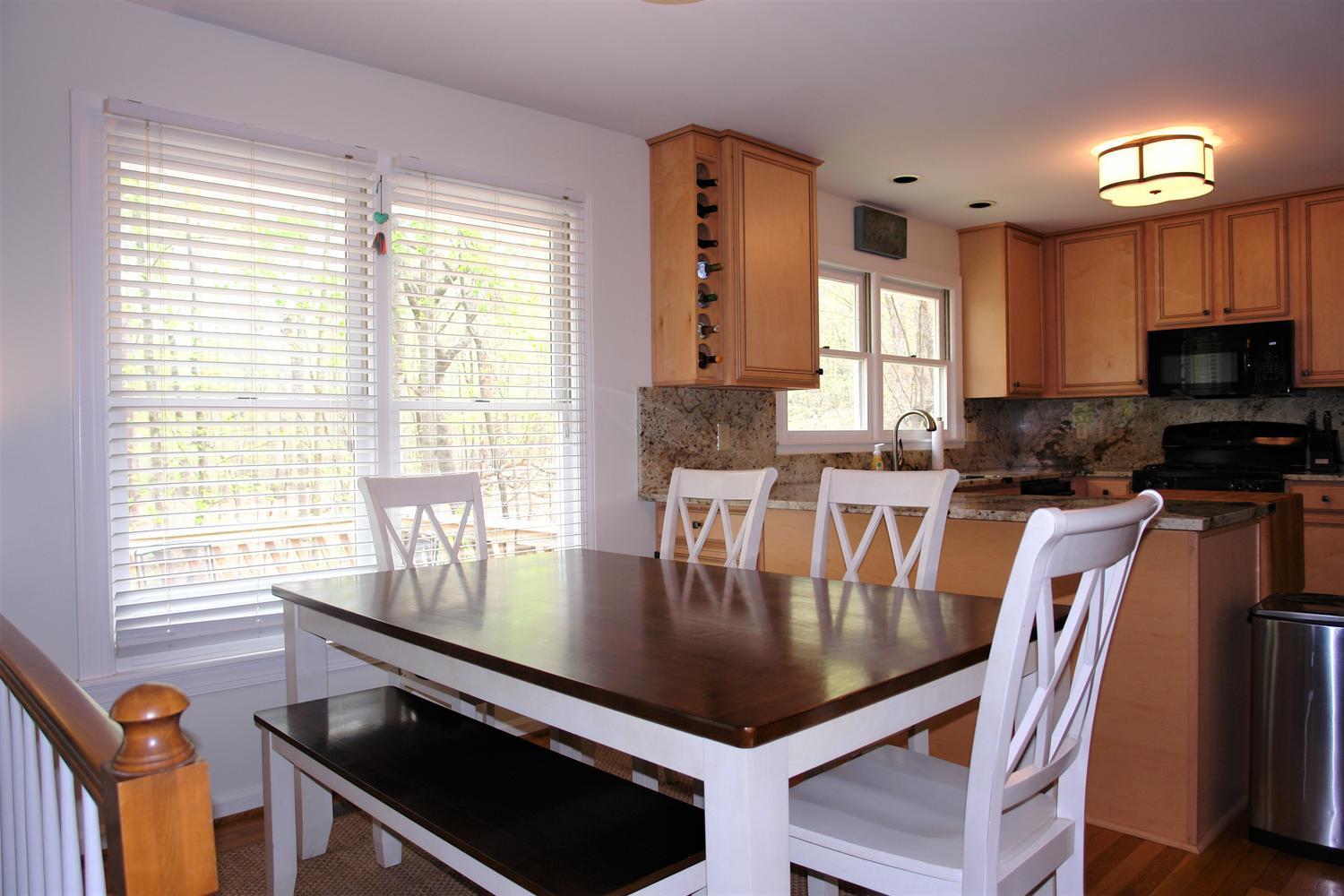 219 Darwin Road Southwest Roanoke, VA 24014 - Photo 17 of 58 a kitchen with a stove a sink dishwasher a dining table and chairs with wooden floor