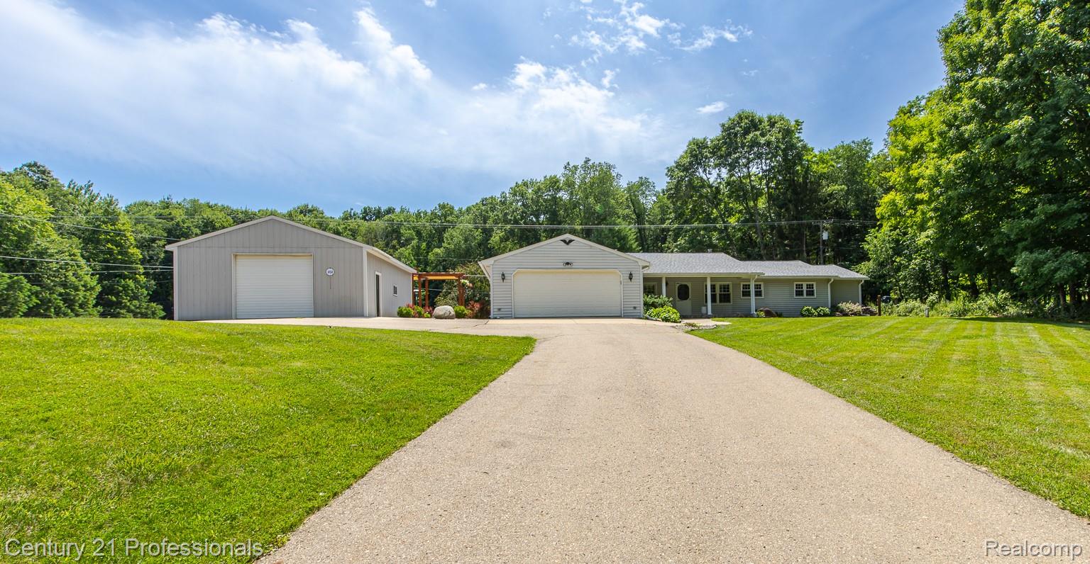 1790 Kent Road Ortonville, MI 48462 - Photo 64 of 64 Expansive paved driveway leading to a ranch-style home with an attached garage and a separate large outbuilding