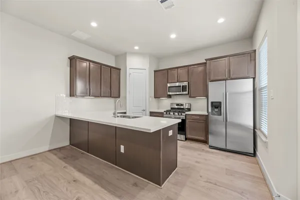 a kitchen with kitchen island a sink stainless steel appliances and cabinets