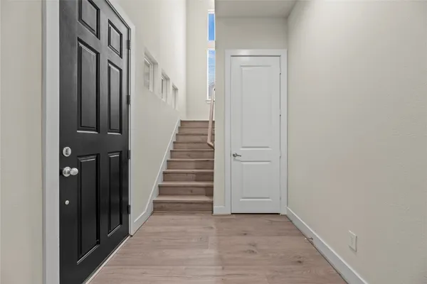 a view of a hallway with wooden floor and entryway