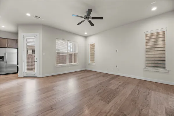 a view of an empty room with a window and wooden floor