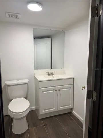 a bathroom with a toilet a sink and mirror