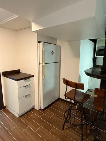 a kitchen with a refrigerator and table chairs