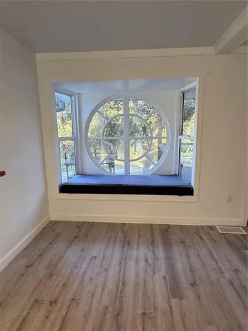 a view of a room with wooden floor and a window