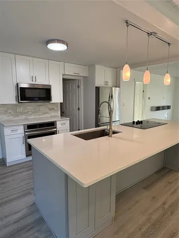a kitchen with kitchen island a sink and a stove