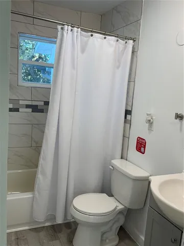 a white toilet sitting next to a shower curtain