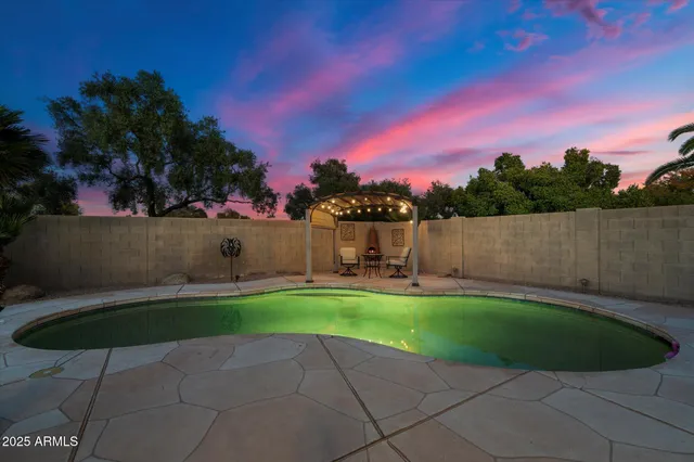 a view of a backyard with a table and chair under an umbrella