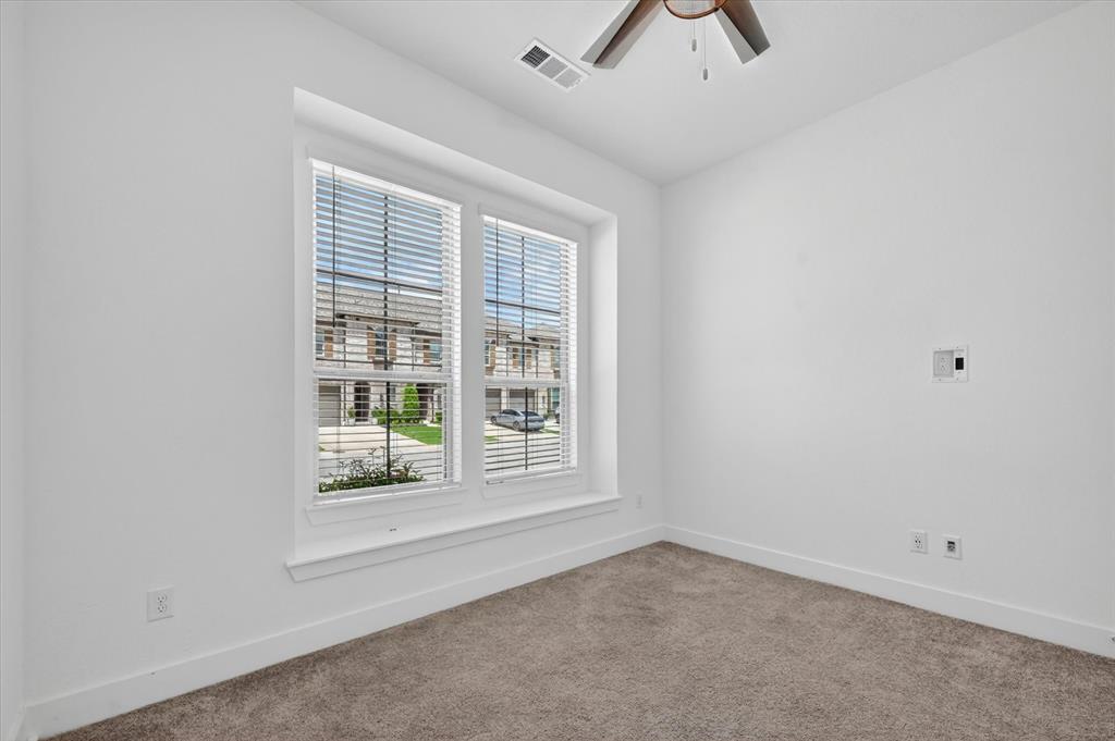1153 Queensdown Way Forney, TX 75126 - Photo 11 of 26 Bright room with neutral carpeting, large double window with blinds, recessed window ledge, white baseboards, and a ceiling fan