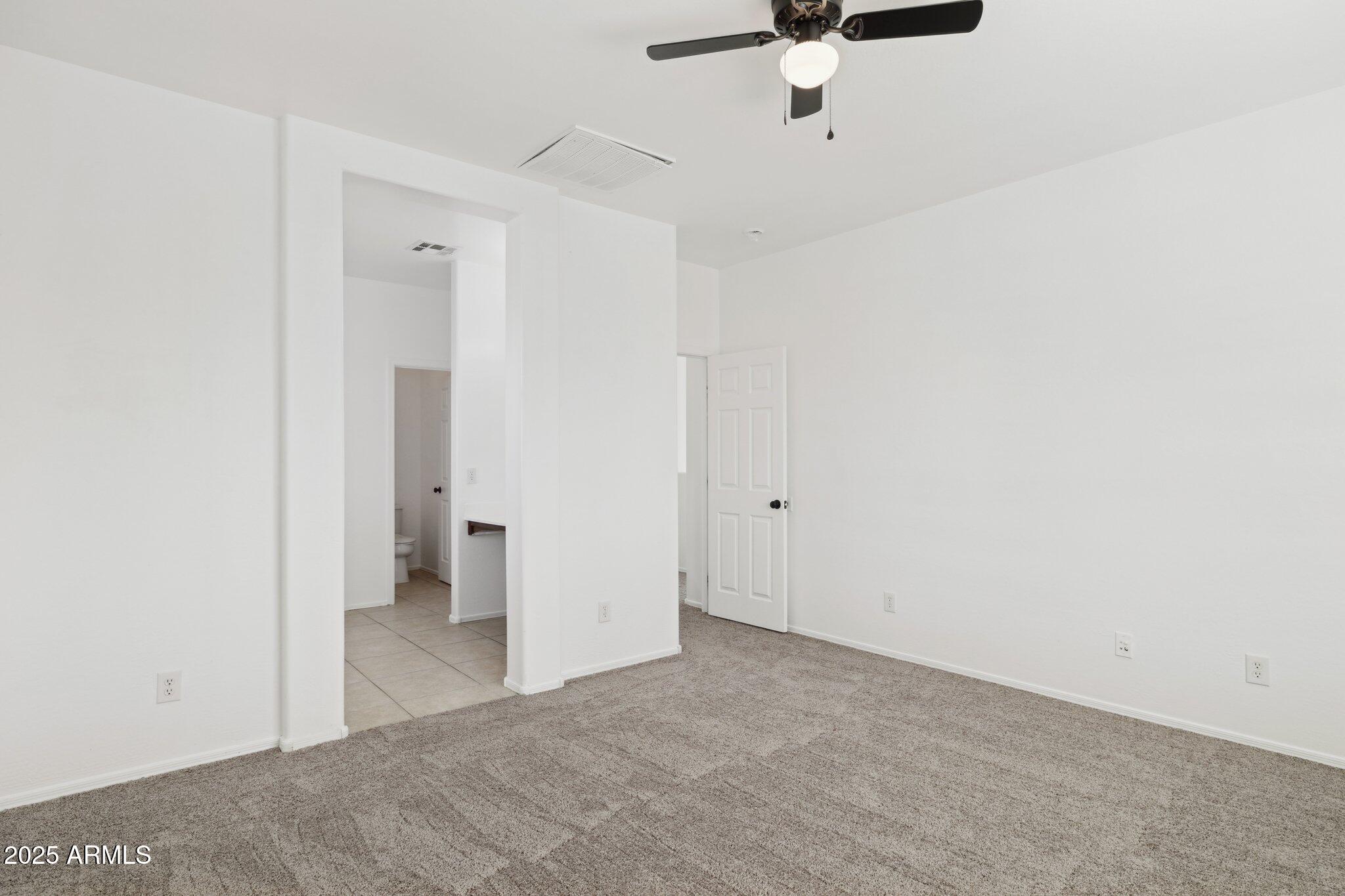 9951 West Bloch Road Tolleson, AZ 85353 - Photo 13 of 33 a view of a room with a ceiling fan and refrigerator