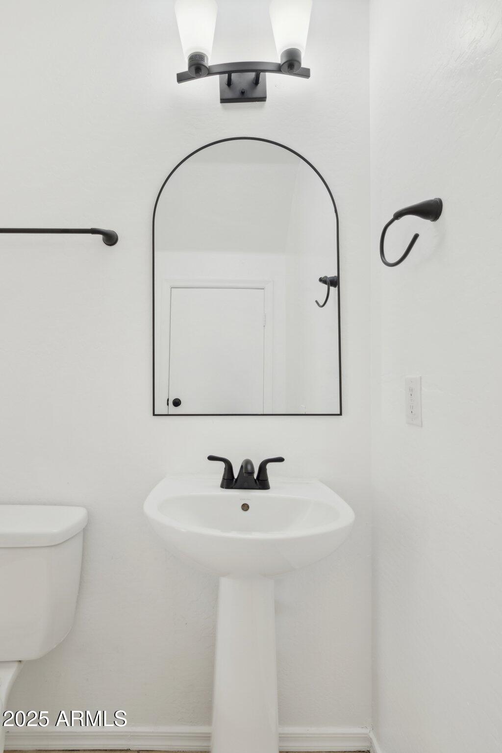 9951 West Bloch Road Tolleson, AZ 85353 - Photo 26 of 33 a bathroom with a sink toilet and mirror