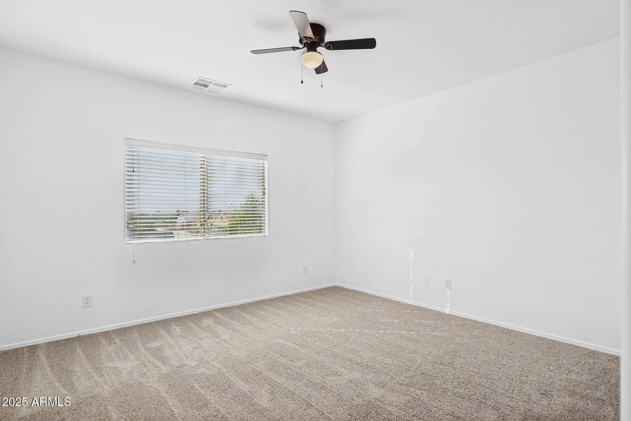 9951 West Bloch Road Tolleson, AZ 85353 - Photo 29 of 33 an empty room with a window and a ceiling fan
