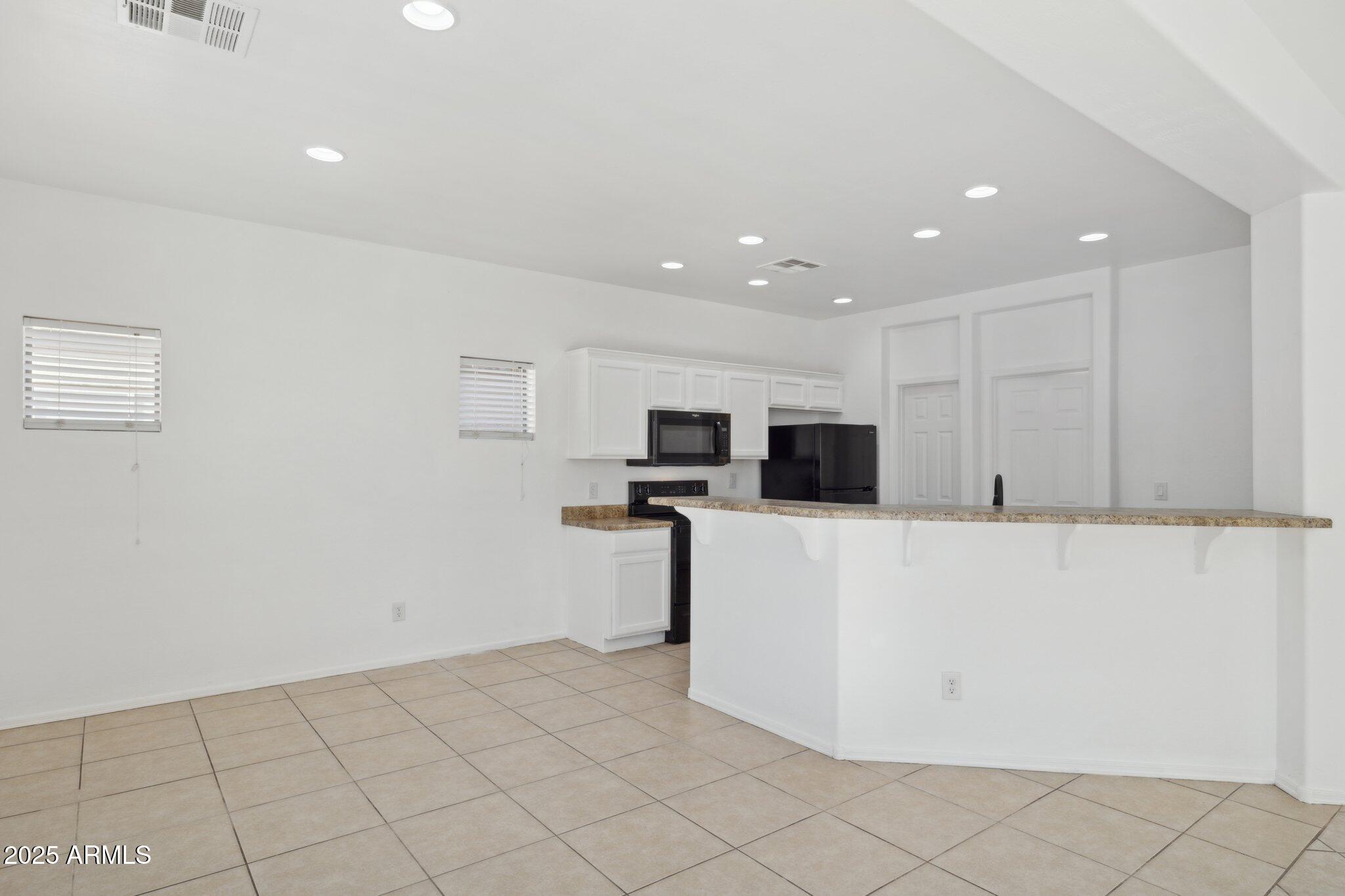 9951 West Bloch Road Tolleson, AZ 85353 - Photo 4 of 33 a view of kitchen with stainless steel appliances refrigerator stove and microwave