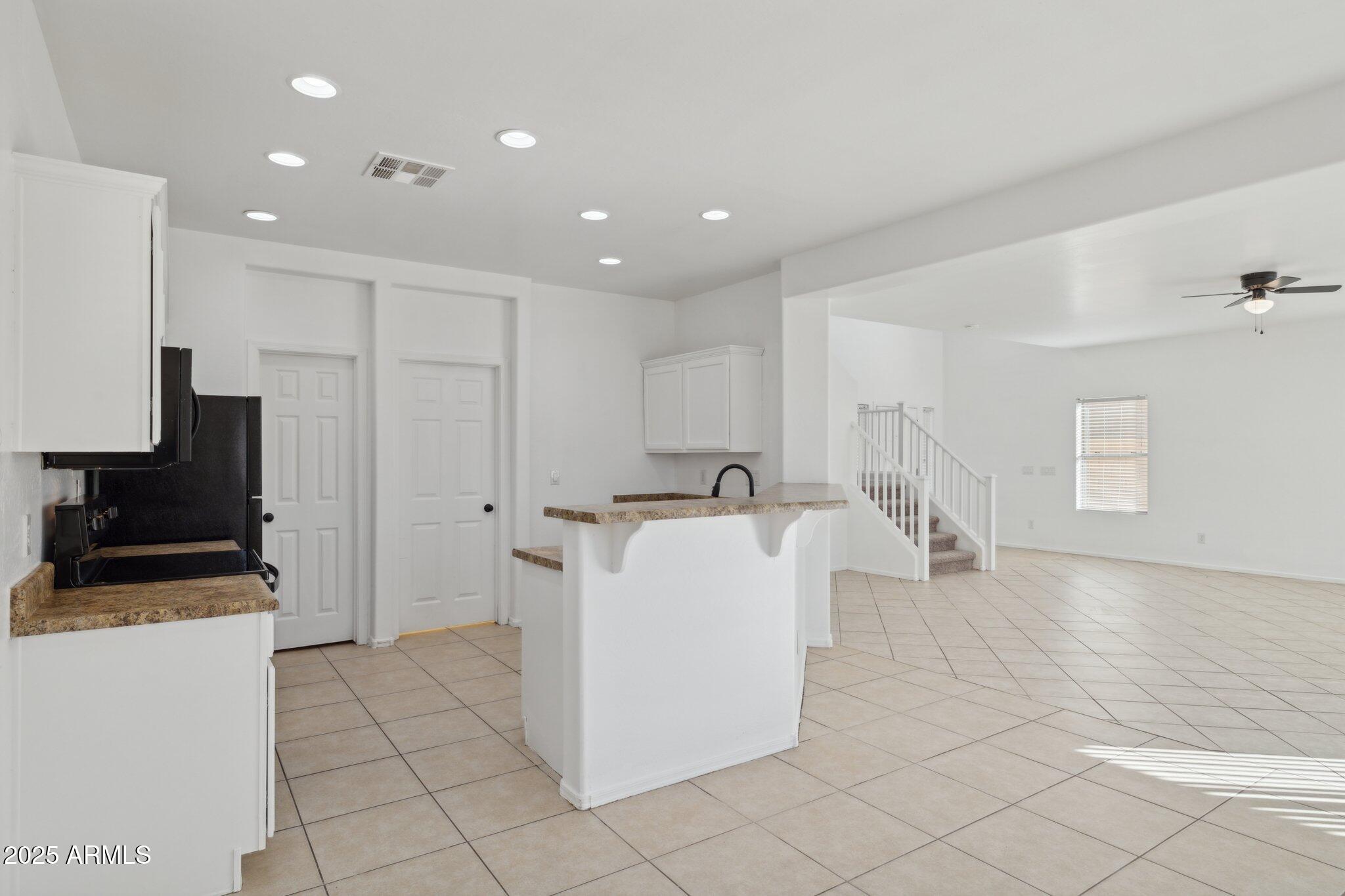 9951 West Bloch Road Tolleson, AZ 85353 - Photo 5 of 33 a living room with stainless steel appliances furniture a rug and a view of kitchen